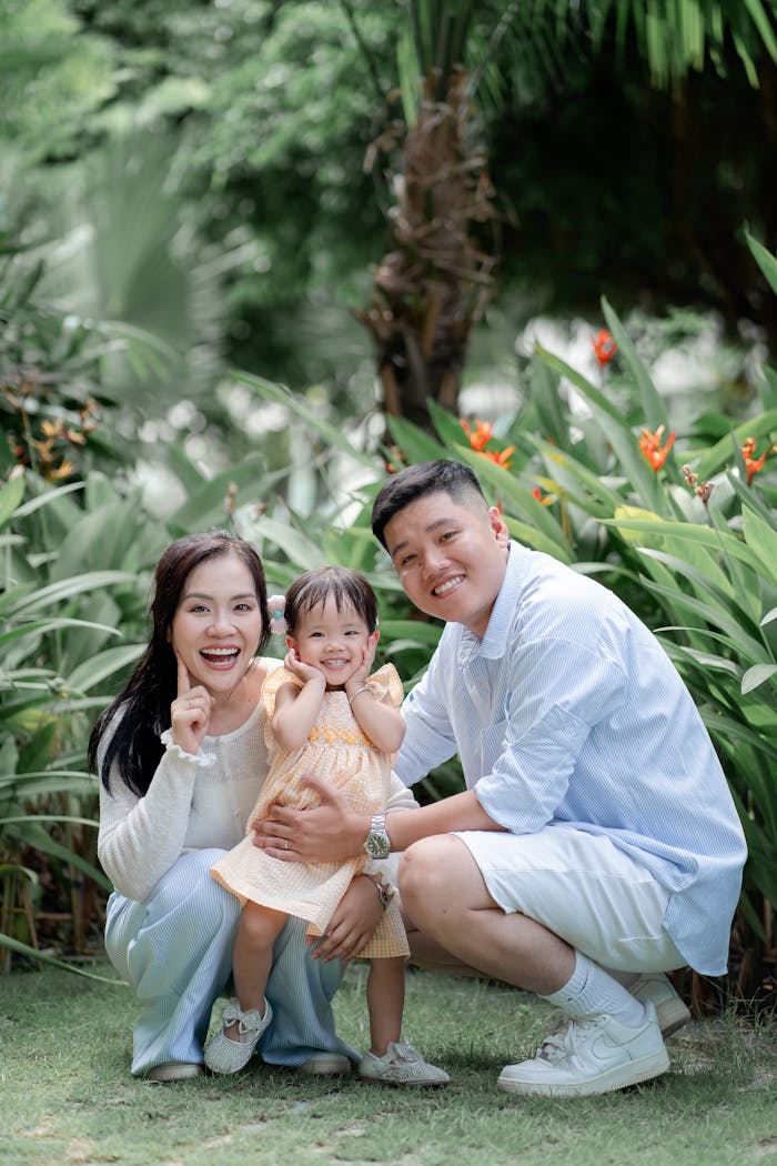 services-04 Smiling family with child in a tropical garden, embracing joy and togetherness.