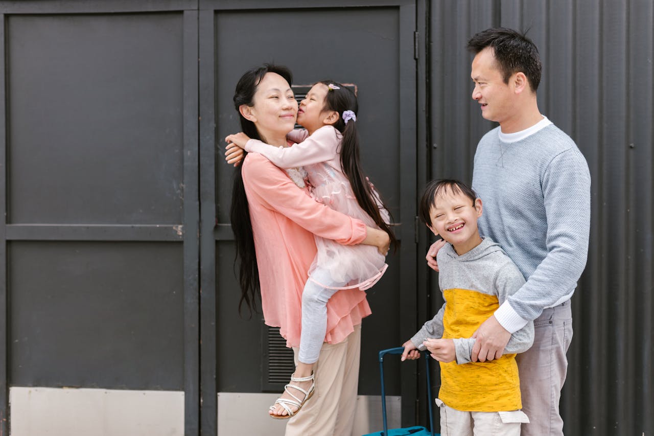 who-we-are Asian family embracing and enjoying time together outdoors, showcasing love and inclusion.